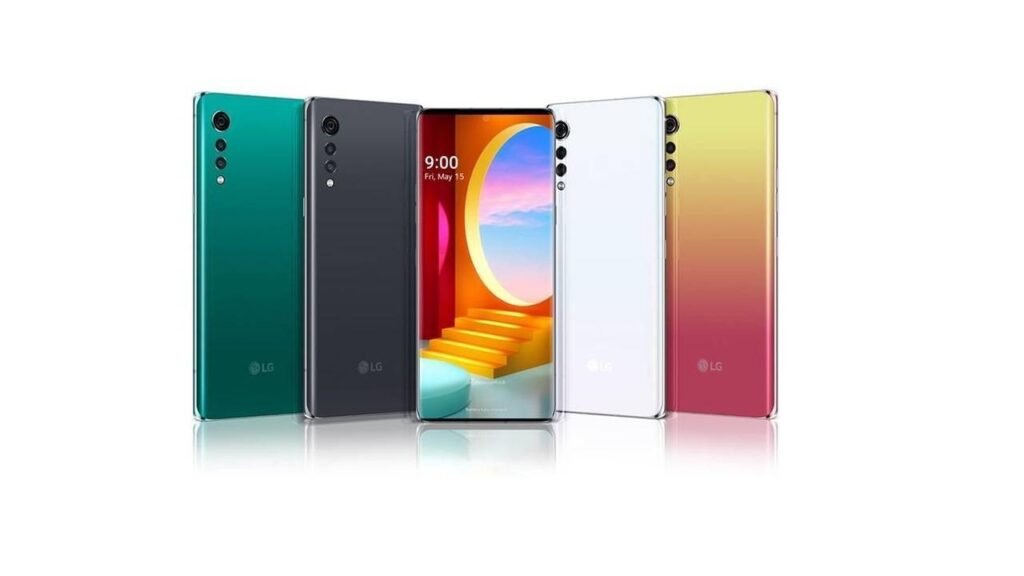 “LG, ADDIO AGLI SMARTPHONE”, serie di smartphone LG disposti in modo da evidenziarne il design e le colorazioni. Al centro, uno dei telefoni mostra lo schermo acceso con un'interfaccia colorata e moderna. Sul retro, gli smartphone hanno un design elegante con fotocamere disposte in verticale lungo l'angolo superiore sinistro. Il logo LG è visibile nella parte inferiore posteriore di ciascun dispositivo. Il design suggerisce un modello della serie LG Velvet, noto per il suo stile curato e la costruzione premium. 